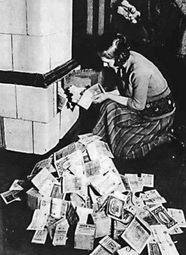Немецкая женщина топит печь деньгами